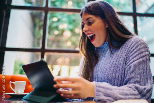 Cuadro en lienzo Shocked Caucasian woman looking at tablet screen with open mouth, surprised by n