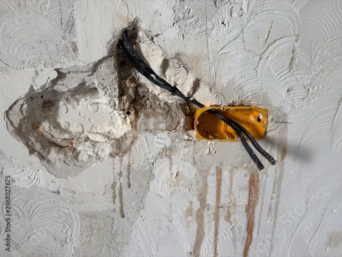 Exposed electrical wiring in damaged wall during renovation