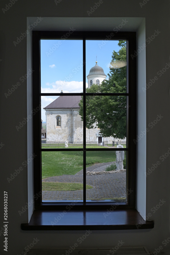 Fototapeta premium View from the museum window to the Church of the Assumption of the Blessed Virgin Mary in Krylos, Ivano-Frankivsk region, Ukraine