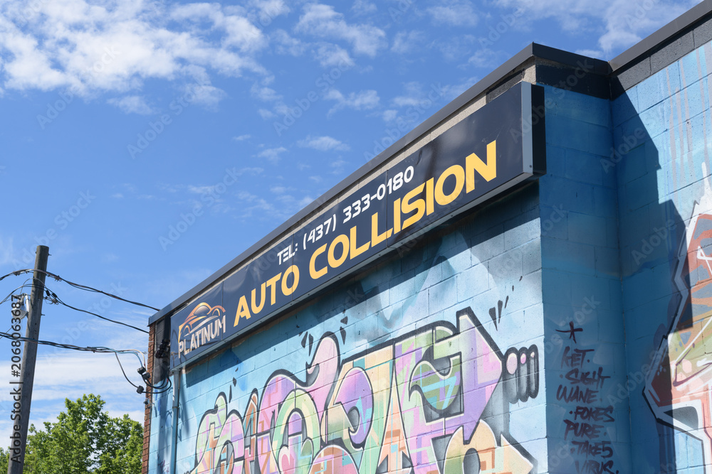Fototapeta premium exterior building facade and sign of Platinum Auto Collision, an auto body shop, located at 2 Cariboo Av, Toronto