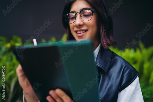 Konstfotografi Close up portrait of smiling hispanic woman looking down at tablet
