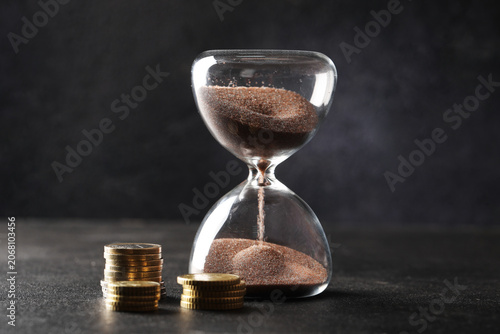 Konstfotografi Hourglass with falling sand and euro coins, time management and financial invest
