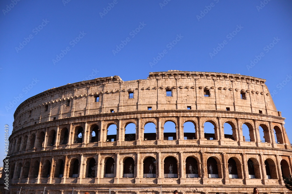 Obraz premium Colosseum Exterior Under Clear Blue Sky in Rome, Italy
