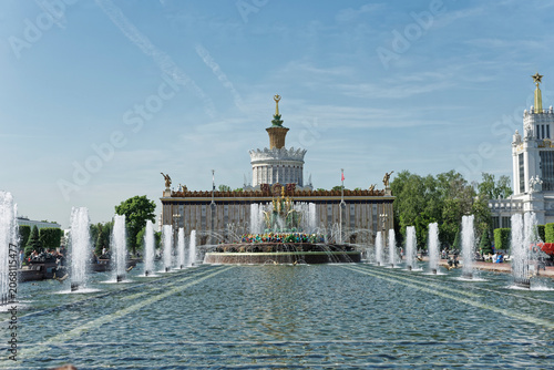MOSCOW, RUSSIA - MAY 5, 2024: Wide view of Stone Flower fountain and Pavilion 58 Agriculture at VDNKh exhibition center, monumental hydro-engineering and cultural heritage architecture
