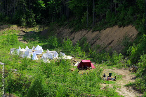 Fotografie Aerial view of a historical reenactment camp with tents set up on a forest edge
