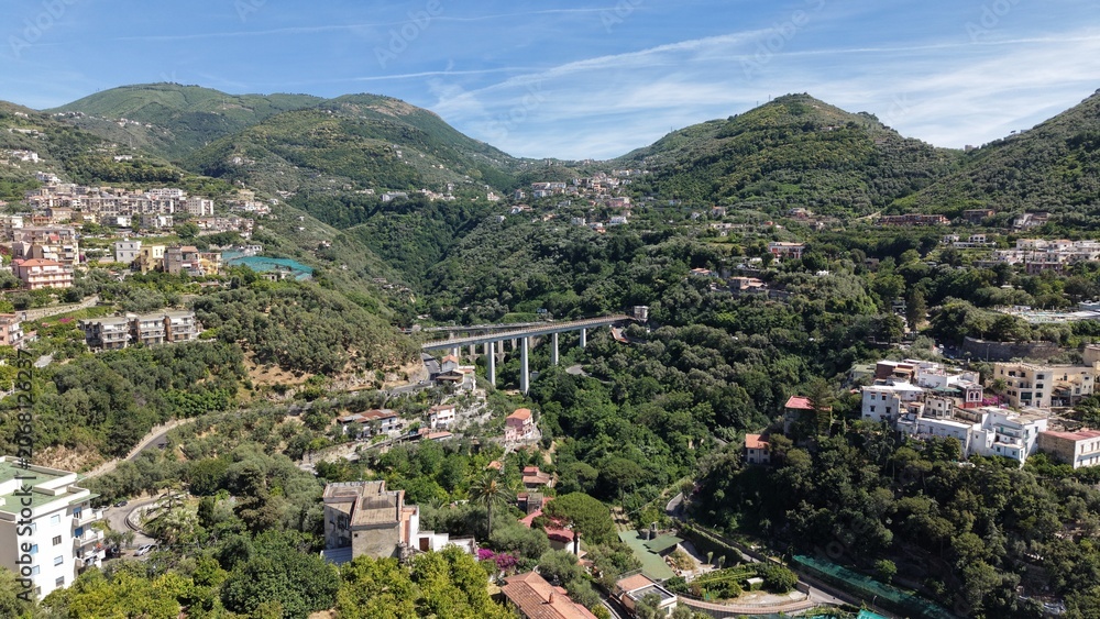 Fototapeta premium Aerial view of historic Ponte di Seiano Bourbon bridge and modern Viadotto del Rivo d'Arco over green valley in Vico Equense, Naples, Italy