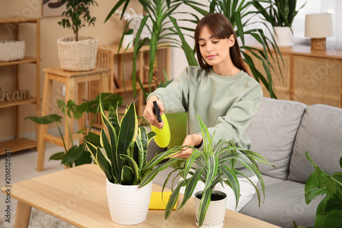 Young female gardener spray...