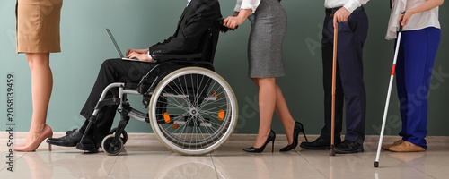 Bild auf Leinwand Job applicants with sticks and man in wheelchair waiting for interview near gree