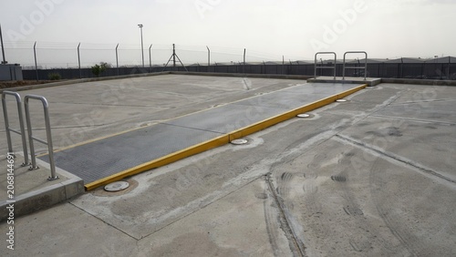 Industrial roof platform features a yellow metal ramp and steel railings for safe access on a flat commercial structure.