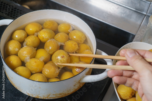 梅の実を鍋で煮る