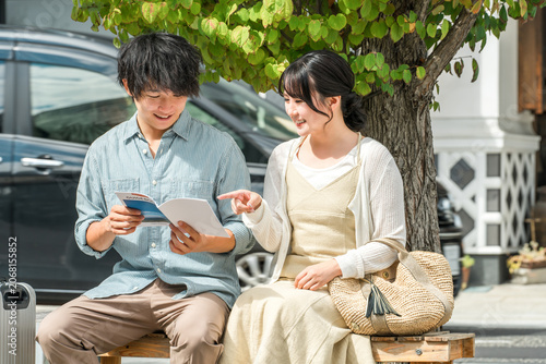 Photography A young couple talking while looking at a guidebook at their travel destination