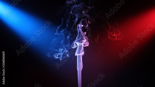 Abstract smoke plumes rising and swirling between red and blue spotlights, isolated on solid background, slow motion