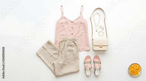 Fashionable outfit laid out with accessories on a clean surface includes clothing and shoes