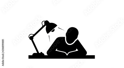 Silhouette of a person reading a book under a desk lamp.