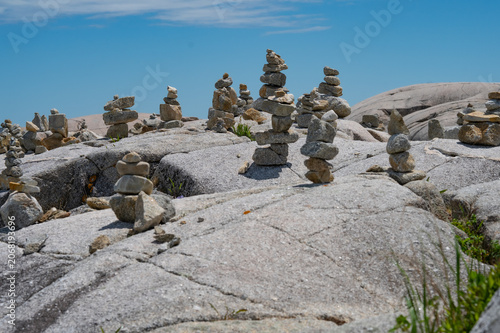 Numerous rock cairns and balancing stones on the coastal granite boulders of Peggy's Cove, Nova Scotia, Canada.