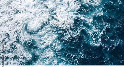 Ocean waves swirl and crash in a deep blue sea with white foam