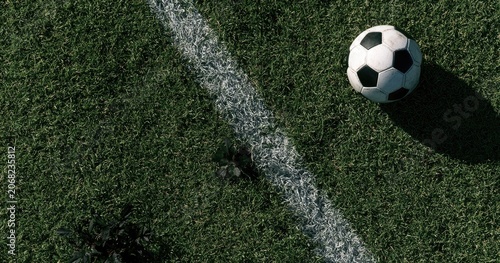 Soccer ball on a green grassy field with a white line