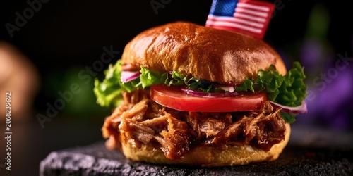 A close-up of a pulled pork sandwich with lettuce, tomato, onion, and flag