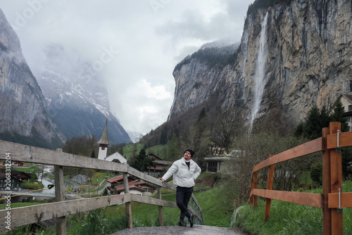 Person Standing Near Wooden Fence in Mountain Valley.