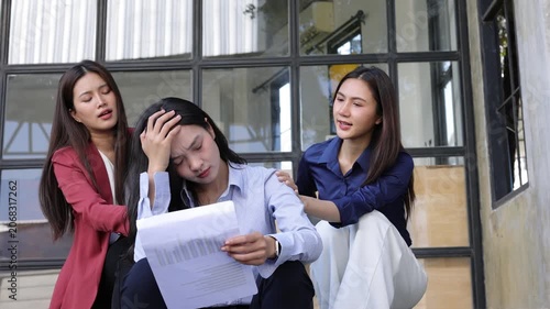 Unemployed asian businesswoman feeling desperate after getting fired. Two female colleagues comforting their sad friend after she lost her job. Unemployed woman feeling stressed and depressed.