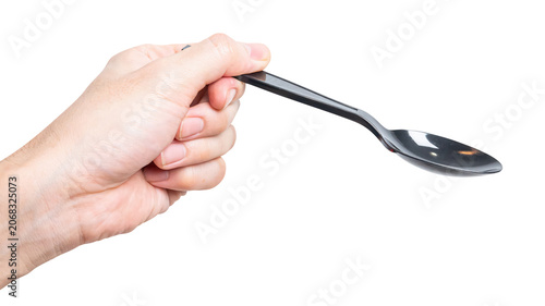 Male hand holding a black plastic spoon isolated on white background.