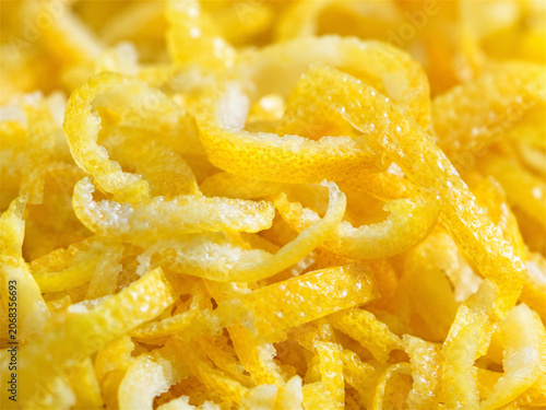 Bright yellow lemon zest curls with sugar crystals fill the frame in a fresh citrus food texture for baking desserts garnish recipes and vibrant culinary background closeup details