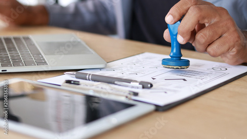 Bild auf Leinwand Business professional stamping approved documents on office desk with laptop and paperwork