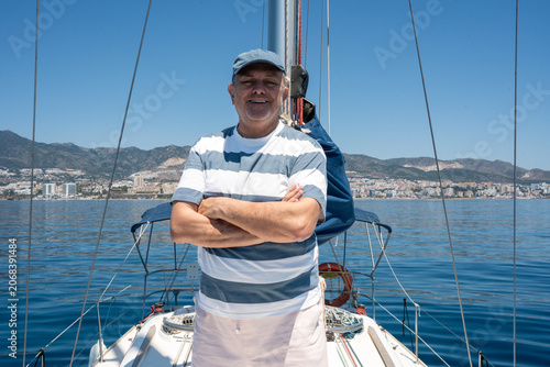 Foto Happy senior man enjoying sailing vacation on sea