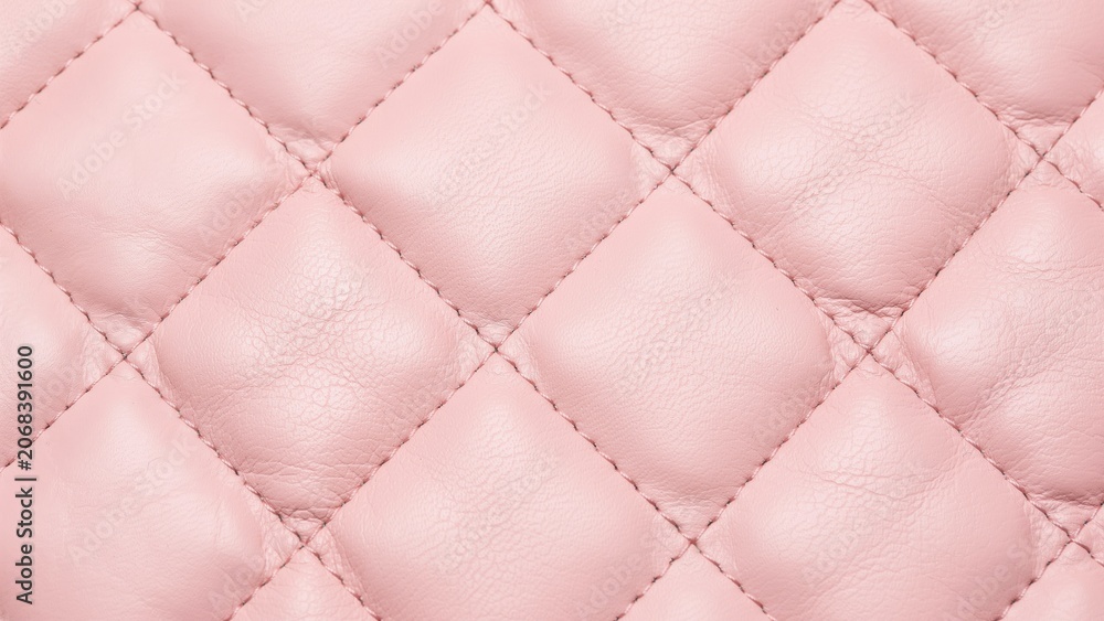 Fototapeta premium Close-up of pink quilted leather texture with diamond stitch pattern
