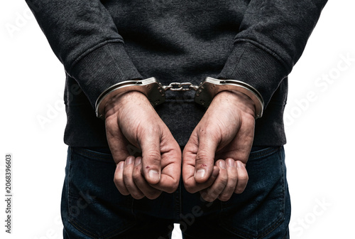 Foto Hands of arrested man in handcuffs behind his back