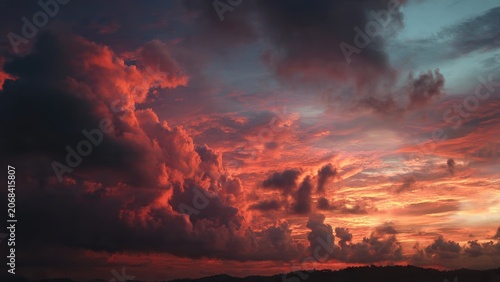 Dramatic sunset with fiery red and orange clouds over a dark landscape silhouette