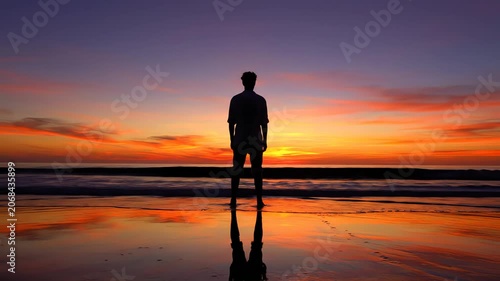 Silhouette of man standing on beach at sunset. 4K Video