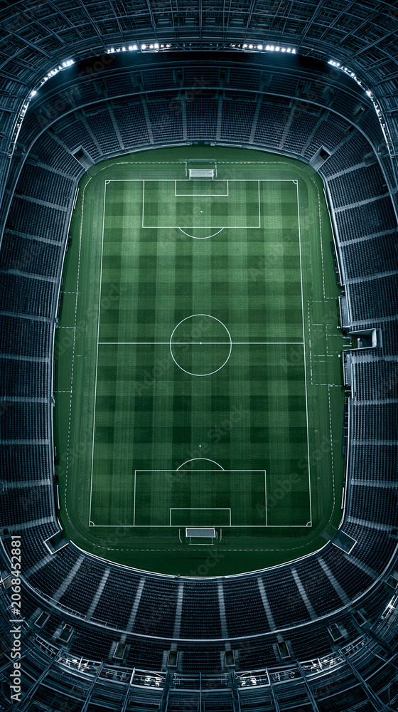 Naklejka premium Soccer Stadium Aerial View: A magnificent soccer stadium from an aerial perspective, showcasing the perfectly manicured green pitch illuminated under the stadium lights.