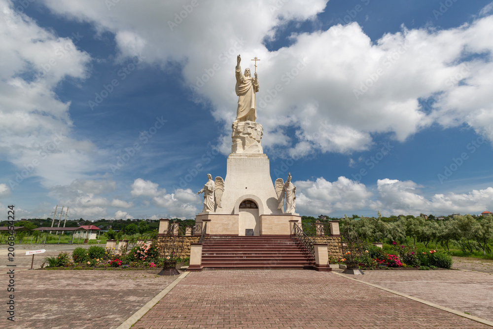 Fototapeta premium Statues of the angels and Christ with a raised hand