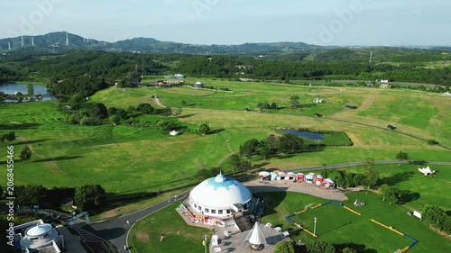 Aerial view of countryside park with white dome building and rolling hills