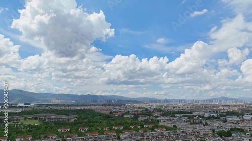 Expansive City Skyline with Distant Mountains and Dramatic Clouds