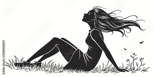 Obraz na płótnie Silhouette of a serene woman sitting in the meadow enjoying the breeze and natur