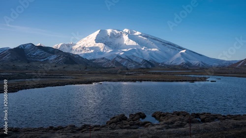 Snow-Covered Mountain Above Calm Lake in an Open Valley at Blue Hour