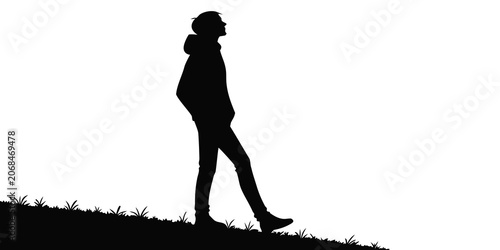Tableau sur toile Silhouette of a man walking up a grassy hill with confidence and determination l