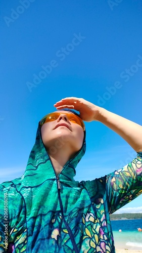 Woman in Sun Protective Clothing Looking Up with Copy Space