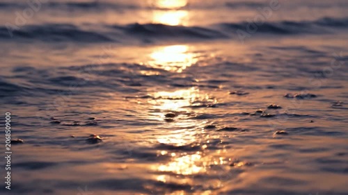 Golden sunset light reflects on gentle ocean waves