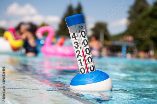 Sommer:  ein Poolthermometer in einem Freibad zeigt eine Wassertemperatur von 27 Grad Celsius an.