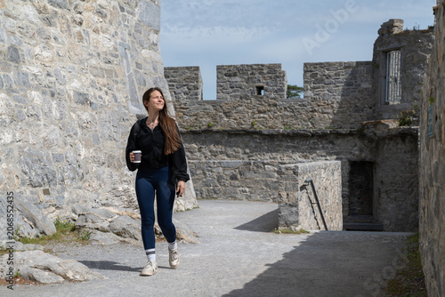 Woman walking through ancient castle walls exploring history