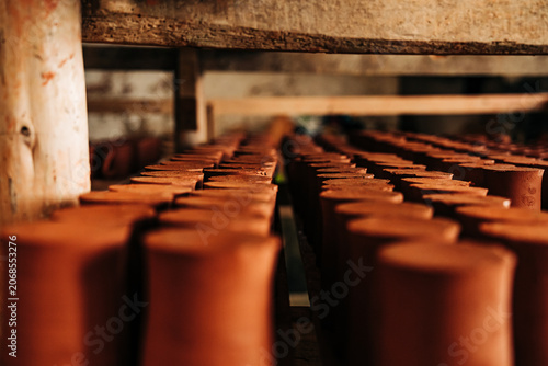 Foto Rows of terracotta cups drying on shelves in pottery workshop