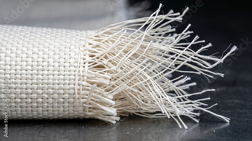 Torn and frayed edge of white ceramic fiber heat shield fabric