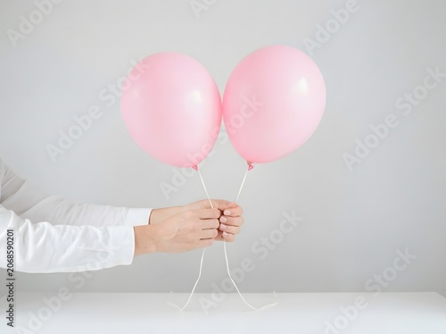 Breast cancer awareness month hands holding pink balloons for support and hope