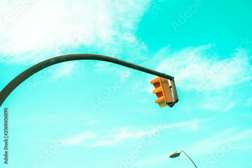 Traffic light pole against blue sky in urban city environment