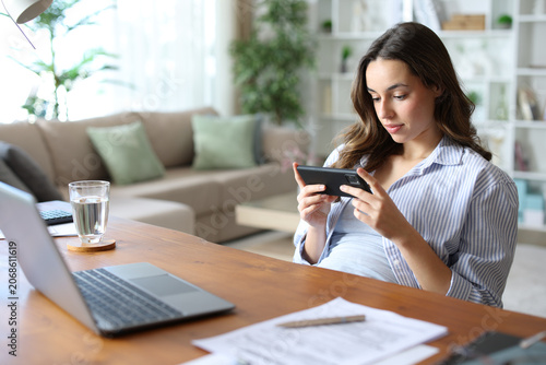 Fotografie Lazy teleworker watching media on phone wasting time