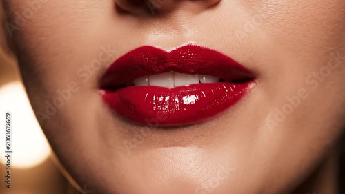 Close up of woman wearing glossy red lipstick on her lips