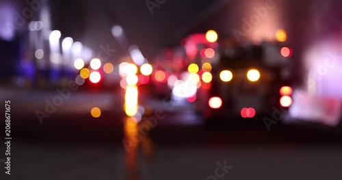 Abstracted de-focused bokeh view of fire engine emergency assets arriving on scene at night.